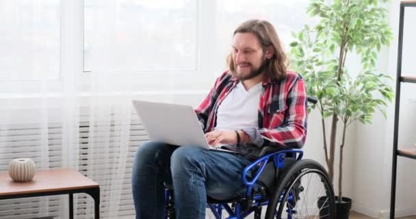 Handicapped man video conferencing using laptop in wheelchair — Vídeos de Stock