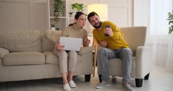 Casal feliz assistindo telefone celular em casa — Vídeo de Stock