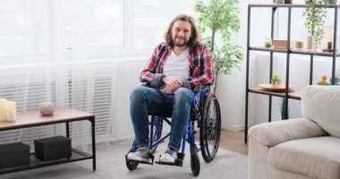 Tekerlekli sandalyede oturan engelli adam gülümsüyor