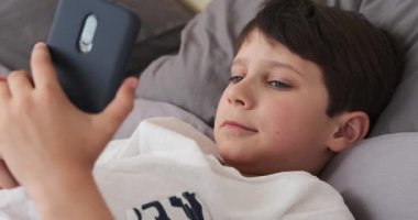 Evde cep telefonu kullanan bir çocuk.