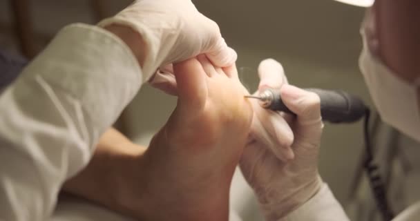Pedikérka s použitím nástroje na odstraňování kožních řas pro péči o nohy — Stock video