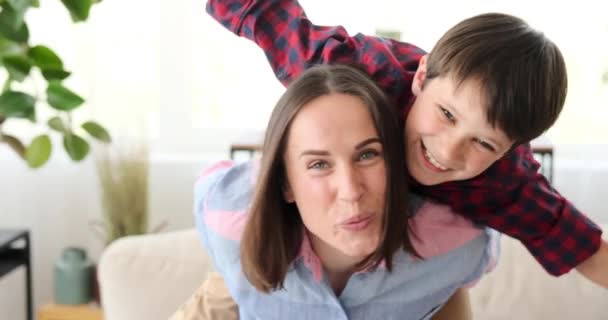 Mãe piggybacking filho em casa — Vídeo de Stock