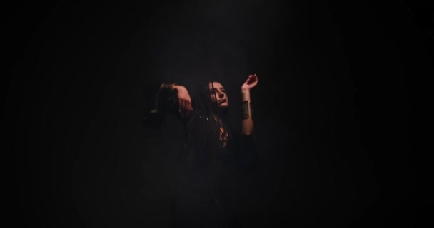 Jeune femme aux cheveux longs dansant en fond noir — Video