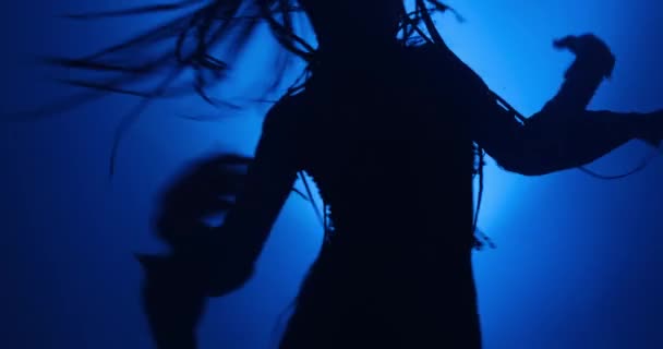 Silhouet van een vrouw die danst in blauw licht en rook — Stockvideo