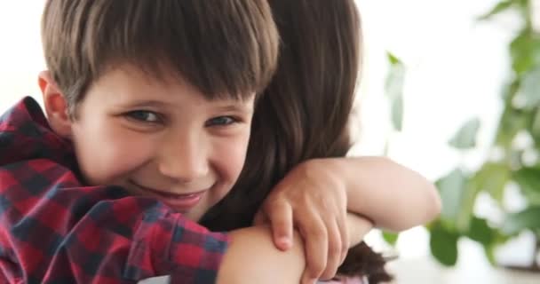 Szerető anya átöleli fiát otthon — Stock videók