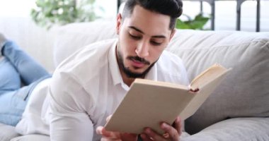 Adam koltukta kitap okuyor.