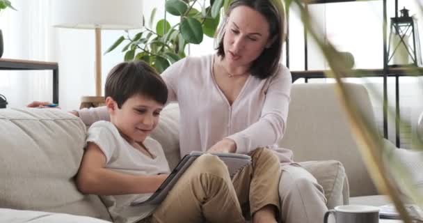 Любящая мать помогает сыну с домашним заданием — стоковое видео