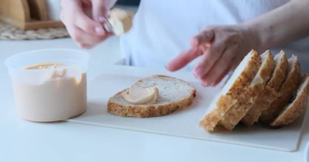 在厨房里用刀把面糊涂在面包上的女人 — 图库视频影像