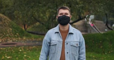 Koruyucu yüz maskesi takan ve yumruğunu kaldıran adam.