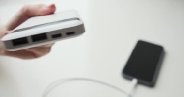 Güç bankasını kabloyla cep telefonuna bağlayan kadın