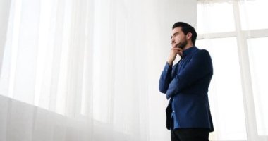 Genç işadamı pencereden dışarı bakıyor.