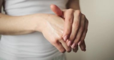 Kadın elinde krem sürüyor.