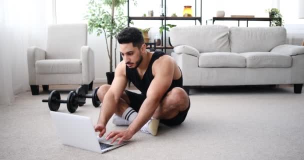 Mladý muž pomocí notebooku, zatímco dělá prkno rameno stepování cvičení — Stock video