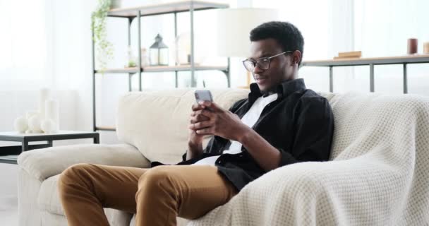 Šťastný mladý muž textové zprávy pomocí mobilního telefonu — Stock video