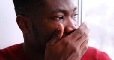 Pencereden dışarı bakan düşünceli bir adam.