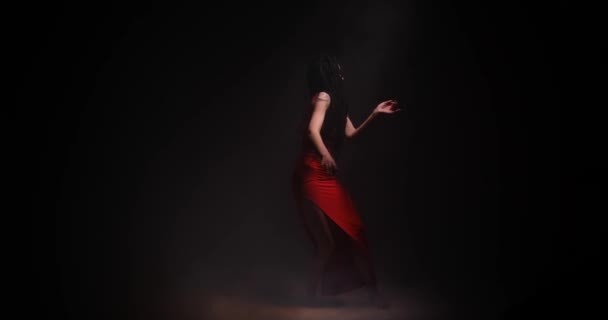 Hermosa mujer con pelo largo bailando en fondo negro — Vídeos de Stock