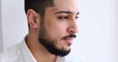 Genç adam pencereden dışarı bakıyor.