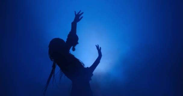 Silhouette di donna che balla in luce blu e fumo — Video Stock