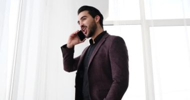 Genç işadamı cep telefonuyla konuşuyor.