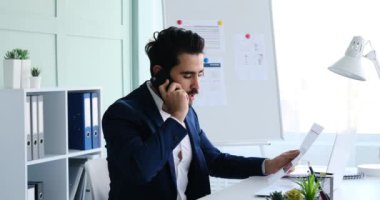 İş adamı çalışırken cep telefonu ve dizüstü bilgisayar kullanıyor