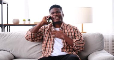Neşeli Afrikalı Amerikalı adam cep telefonuyla konuşuyor.