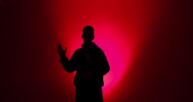 Kırmızı ışıkta dans eden bir adamın silueti