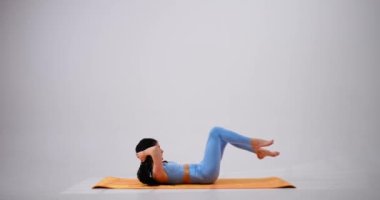 Genç bir kadın mekik çekiyor.