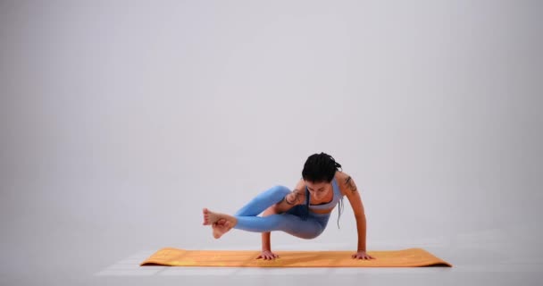 Mujer joven practicando astavakrasana yoga pose — Vídeos de Stock