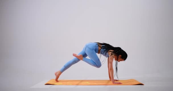 Junge Frau praktiziert Virabhadrasana-Kriegerin eine Yoga-Pose — Stockvideo