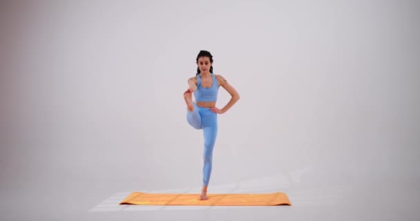Jovem mulher praticando árvore ou vrksasana ioga pose — Vídeo de Stock