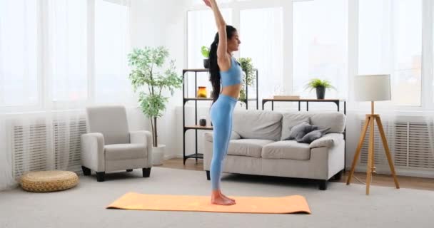 Ung kvinne som gjør dekasana og parivritta parsvakonasana parivritta yoga positur – stockvideo