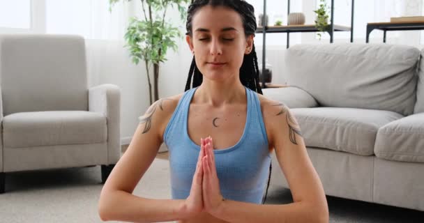 Junge Frau meditiert in Lotusposition im Wohnzimmer — Stockvideo