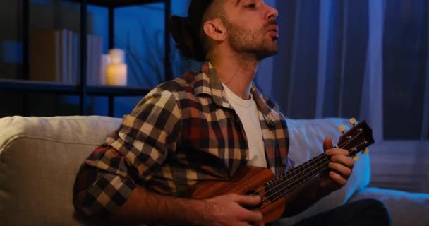 Jovem cantando e tocando guitarra ukulele em casa — Vídeo de Stock
