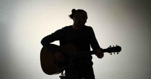 Молода людина співає і грає на гітарі — стокове відео