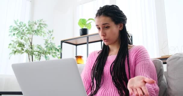 Mujer vídeo chat con el ordenador portátil sentado en el sofá — Vídeo de stock