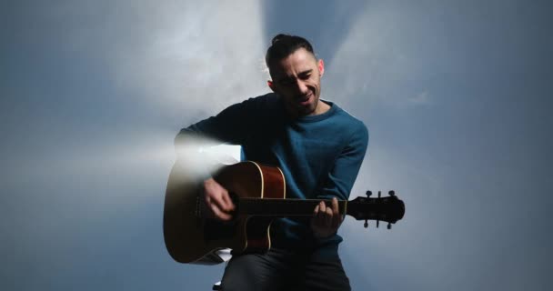 Confident young man singing and playing guitar — Stock Video