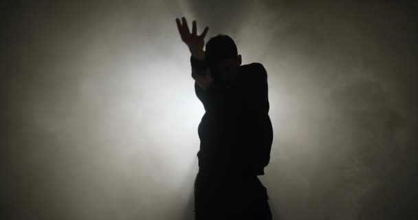 Silueta de hombre joven haciendo danza estilo hiphop — Vídeo de stock