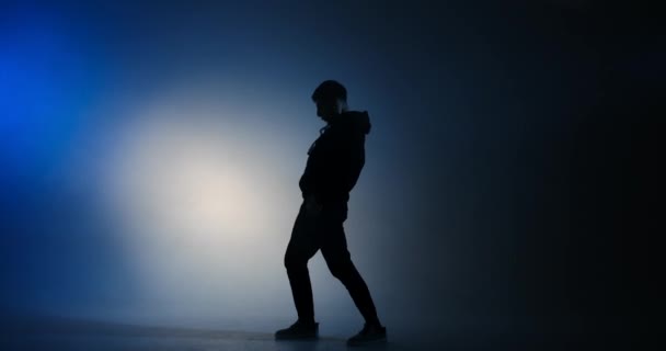 Jovem dançando em estilo hiphop em luz azul — Vídeo de Stock