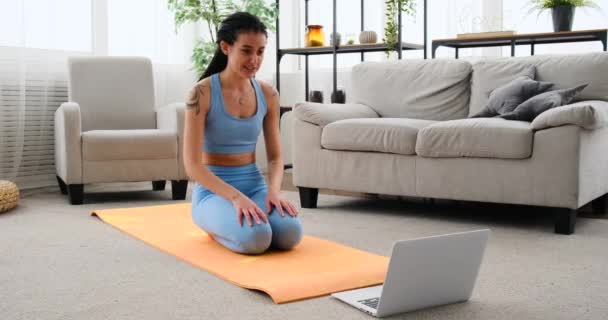 Mujer joven practicando balanceo piernas ejercicio y haciendo empujar hacia arriba mientras se utiliza el ordenador portátil — Vídeos de Stock