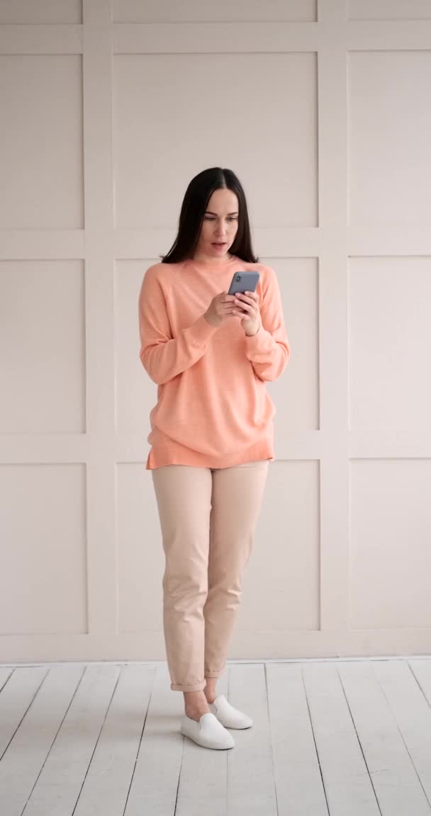Vrouw geschokt op het ontvangen van negatief nieuws met behulp van mobiele telefoon — Stockvideo