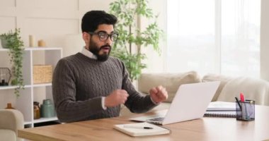 İş adamı dizüstü bilgisayarda çalışıyor ve başarıyı kutluyor