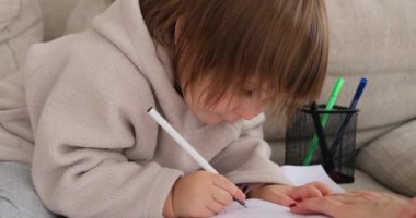 Anne ve kızı evde kağıda çizim yapıyor.