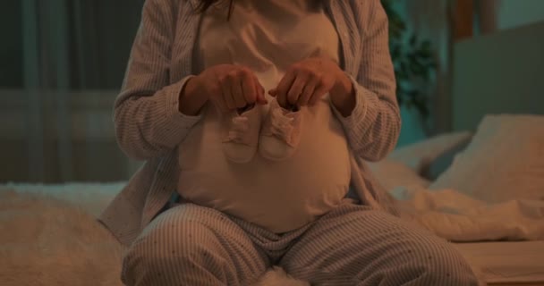Mujer juguetona caminando zapatos de bebé en su vientre embarazada en casa — Vídeo de stock