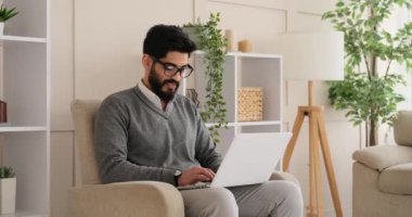 Koltukta dizüstü bilgisayar kullanan adam