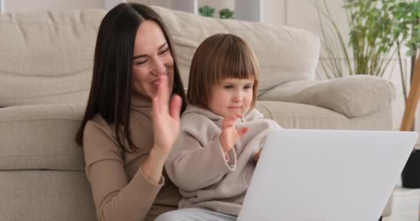 Gioioso madre e figlia utilizzando il computer portatile a casa — Video Stock