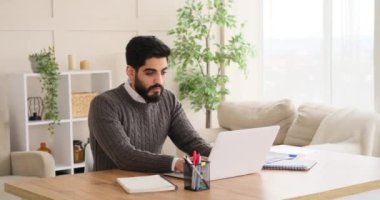 Dizüstü bilgisayarda çalışan ve belgeyi analiz eden iş adamı