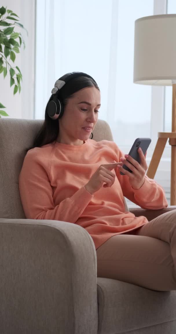 Müzik dinleyen ve cep telefonu kullanan bir kadın. — Stok video