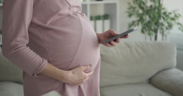 Mujer embarazada usando teléfono móvil en casa — Vídeos de Stock
