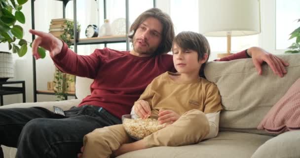 父と息子は家でテレビで映画を見ます — ストック動画
