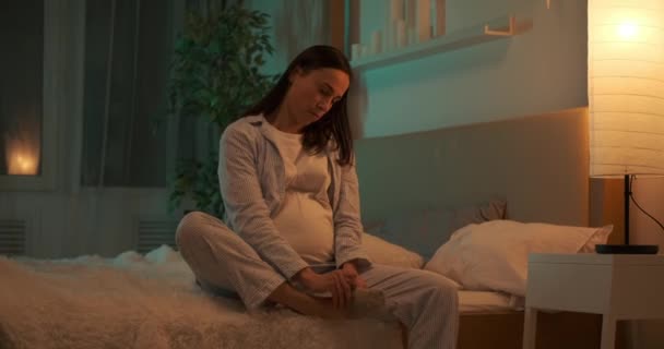 양말을 신고 침대에서 일어나는 임신부 — 비디오